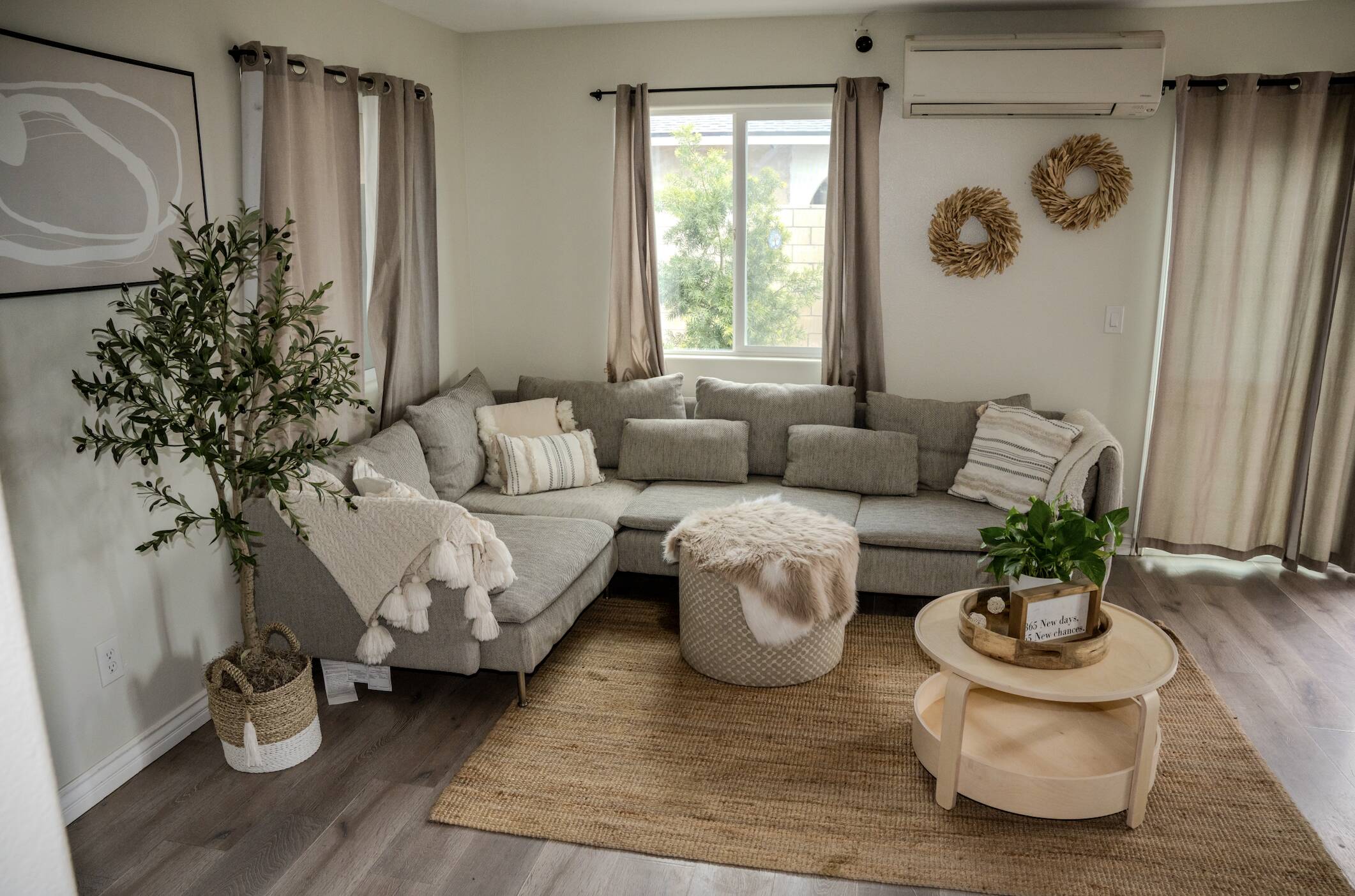 Cozy living room inside Fresh Start of California’s rehab facility, featuring a neutral-toned sectional sofa, indoor plants, soft natural lighting, and modern home decor.
